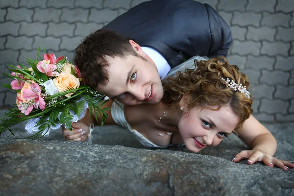 Bruden och brudgummen nära en vägg — Stockfoto
