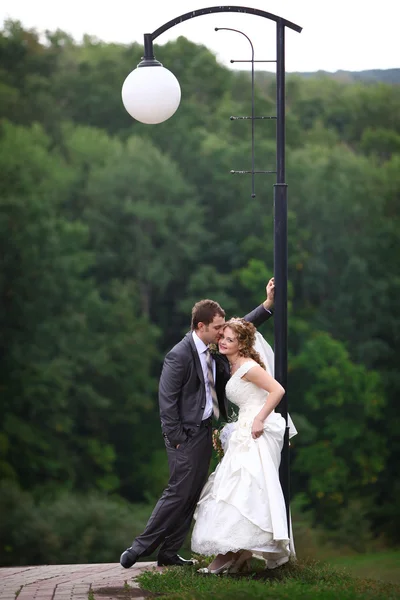 Bride and groom under lantern — Stock Photo, Image