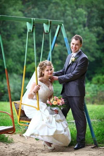 Bride and groom on swing — Stock Photo, Image