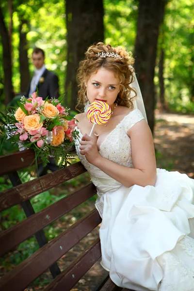 Groom and bride with lollypop — Stock Photo, Image