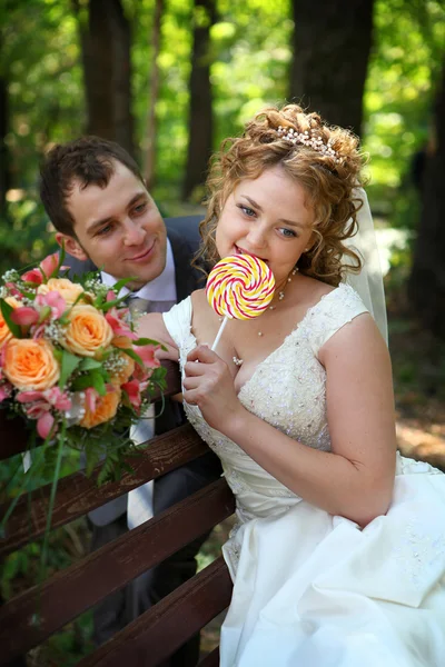 Groom and bride with lollypop — Stock Photo, Image