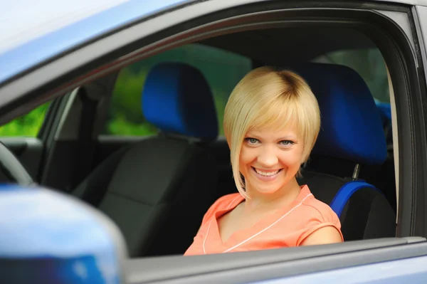 Lächelnde junge Frau im Auto — Stockfoto
