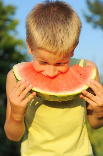 Mladý chlapec jíst meloun — Stock fotografie