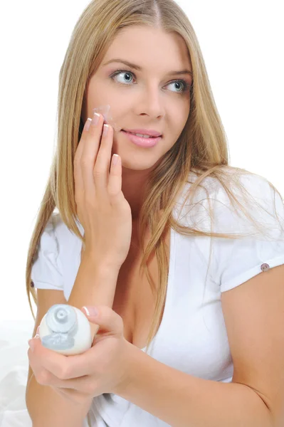 Beautiful woman applying cream on her cheek — Stock Photo, Image