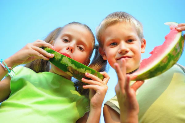 Junge und Mädchen essen Wassermelone lizenzfreie Stockfotos