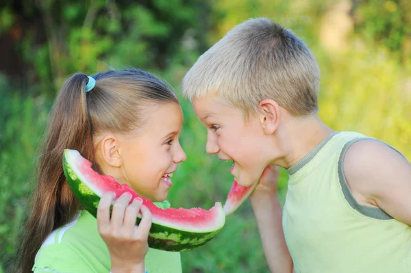 Giovane ragazza e ragazzo mangiare anguria — Foto Stock