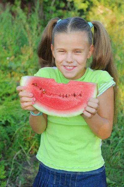Jong meisje eten watermeloen — Stockfoto
