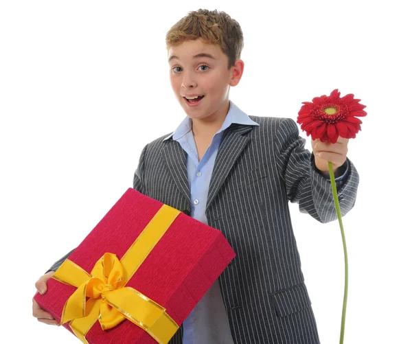 Menino com uma caixa de presente e uma flor — Fotografia de Stock