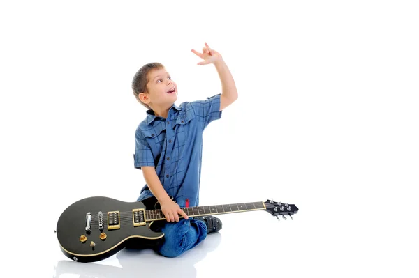 Маленький музыкант играет на гитаре — стоковое фото