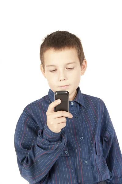 stock image The boy looks at a mobile phone