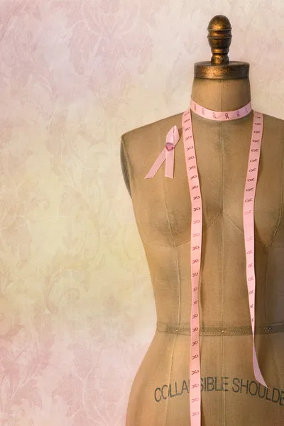 Fita de câncer de mama rosa no manequim com fundo vintage — Fotografia de Stock