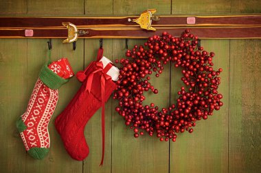 Christmas stockings and wreath hanging on wall clipart