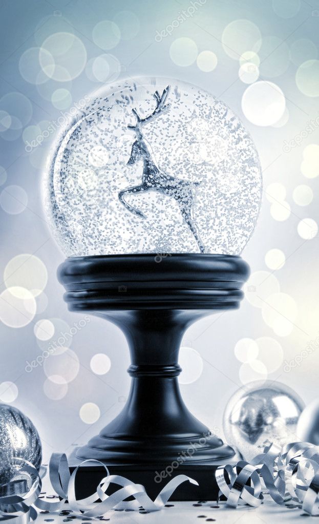 Snow globe with ornaments against festive background