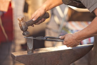 Hammer, anvil and the hands of a blacksmith clipart