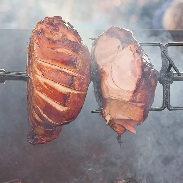 Ogromne kawałki mięsa wieprzowego, pieczenie na rożnie — Zdjęcie stockowe