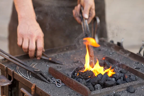 Żar, ogień, dym, narzędzia i ręce kowala — Zdjęcie stockowe