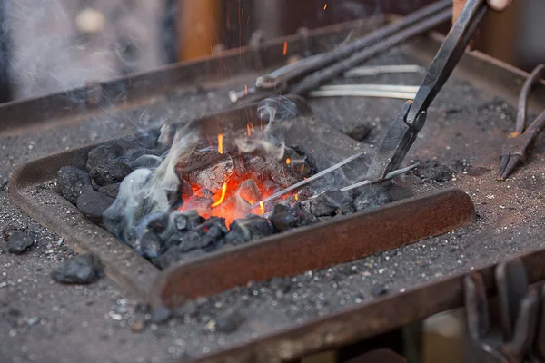 Brasas, fuego, humo y herramientas de herrero — Foto de Stock