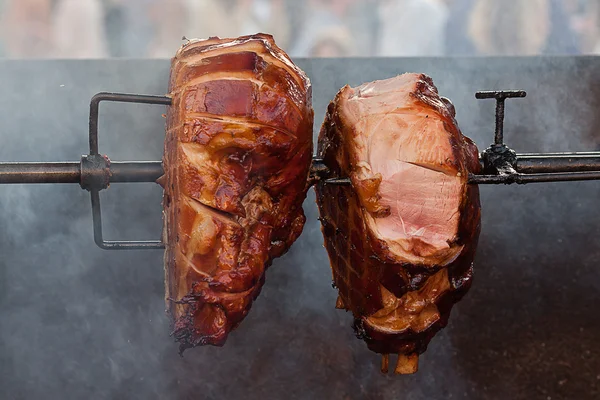 Pezzi enormi di arrosto di maiale su uno spiedo — Foto Stock