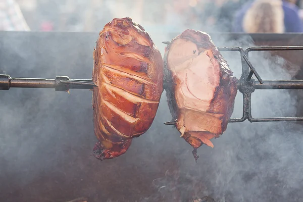 Ogromne kawałki mięsa wieprzowego, pieczenie na rożnie — Zdjęcie stockowe