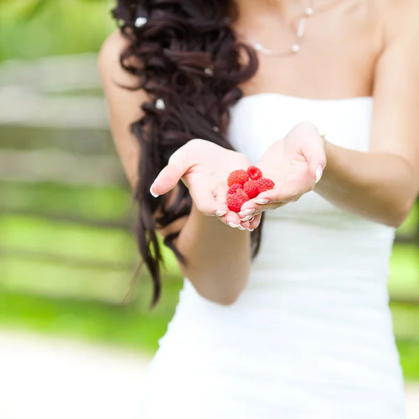 stock image Juicy red raspberries in the hands of the bride