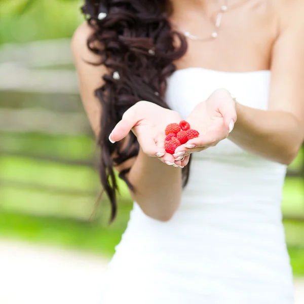 Juicy red raspberries in the hands of the bride — Stock Photo, Image