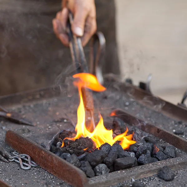Żar, ogień, dym, narzędzia i ręce kowala — Zdjęcie stockowe