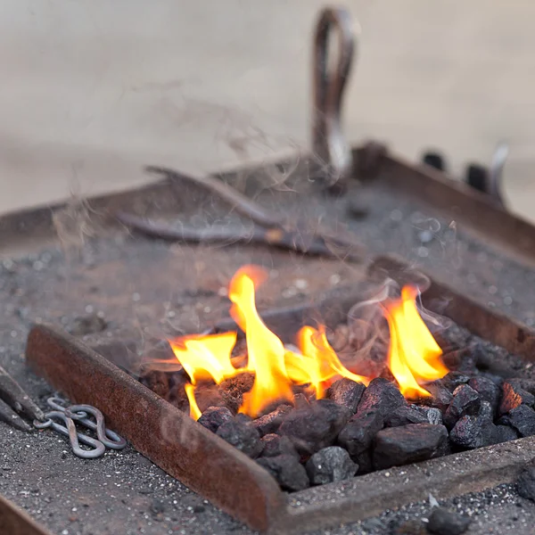 Brasas, fuego, humo y herramientas de herrero — Foto de Stock