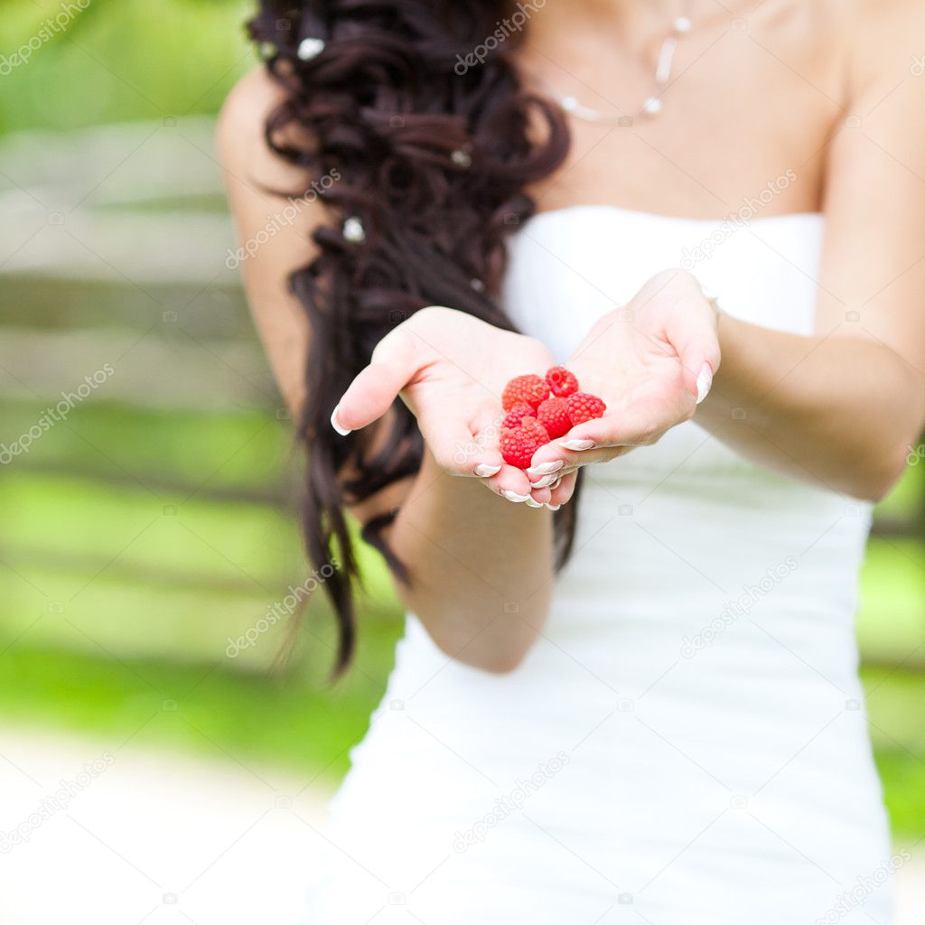 Juicy red raspberries in the hands of the bride