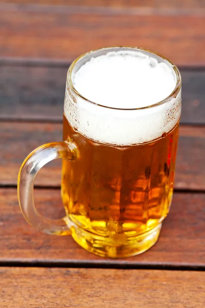 Taza con cerveza ligera de pie sobre la mesa —  Fotos de Stock