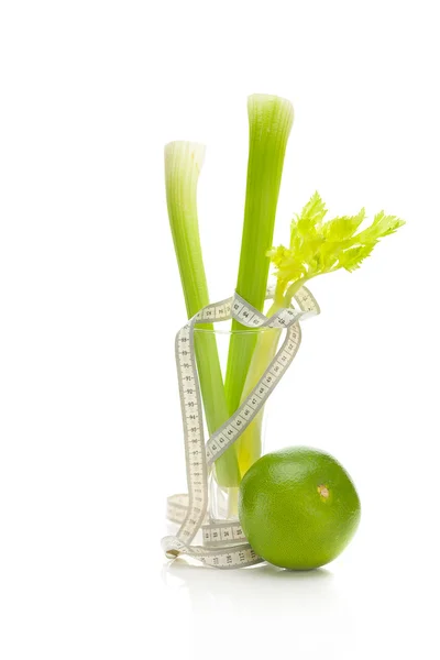 Sedano in un bicchiere alto, pompelmo verde e nastro isolante misura — Foto Stock
