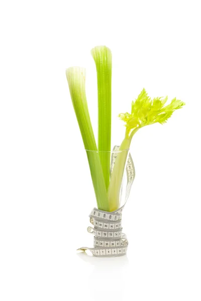 Celery in a tall glass and measure tape isolated on white — Stock Photo, Image