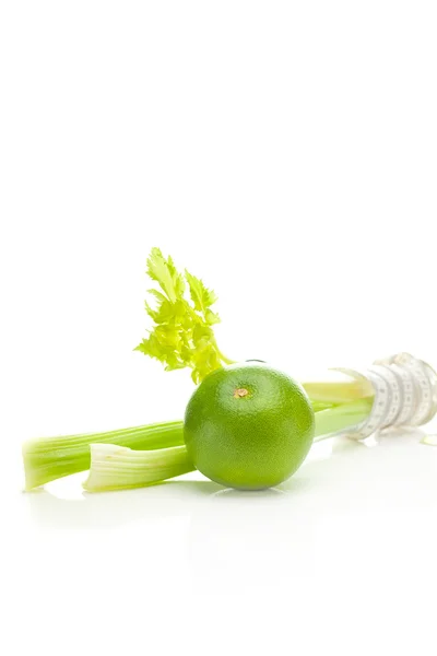 Celery in a tall glass, green grapefruit and measure tape isolat — Stock Photo, Image