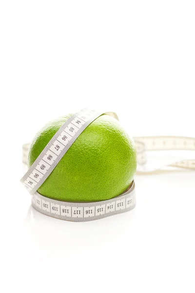 Stock image Green grapefruit and measure tape isolated on white