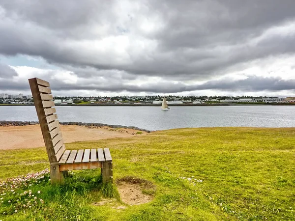 Деревянная скамейка на реке — стоковое фото