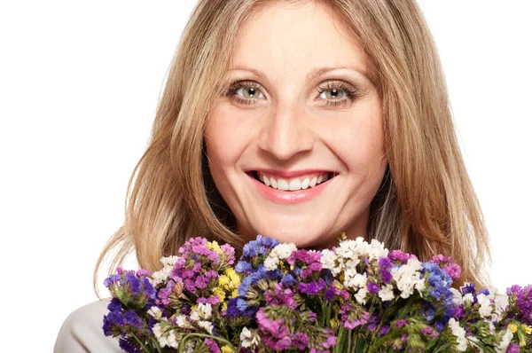 Donna bionda sorridente con mazzo di fiori di campo — Foto Stock
