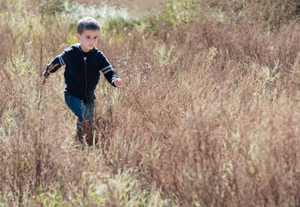 Litle boy runs through the prairie — Stock Photo, Image