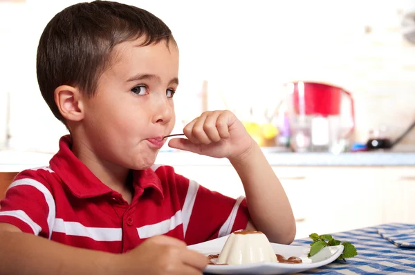 Kleine jongen met lepel eet dessert — Stockfoto