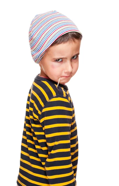 Маленький хулиган с зубочисткой и синяком под глазом в полосатом свитере — стоковое фото