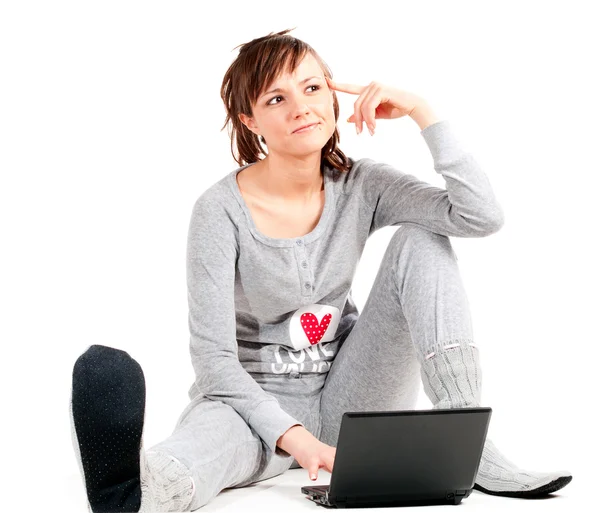 Молодая женщина в пижаме с ноутбуком — стоковое фото