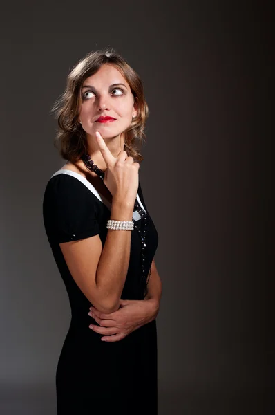 Tankeväckande retro kvinna i svart klänning — Stockfoto
