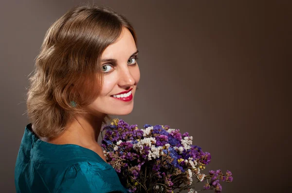 Χαμογελαστή γυναίκα με λουλούδια — Φωτογραφία Αρχείου
