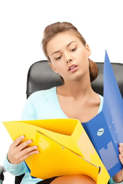 Молода бізнес-леді з папками, сидячи в кріслі — стокове фото