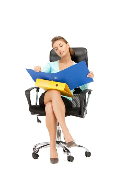 Klasörlerle sandalyede oturan genç iş kadını — Stok fotoğraf
