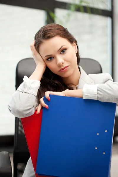 Jonge zakenvrouw met mappen zittend in stoel — Stockfoto
