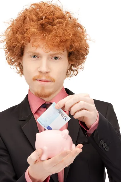 Mann mit Sparschwein und Geld — Stockfoto
