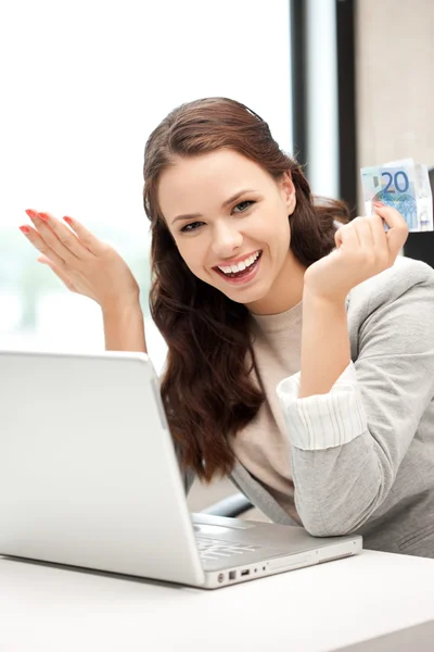 Glad kvinna med dator och euro i kontanter — Stockfoto