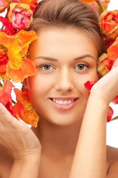Schöne Frau mit roten Blumen — Stockfoto