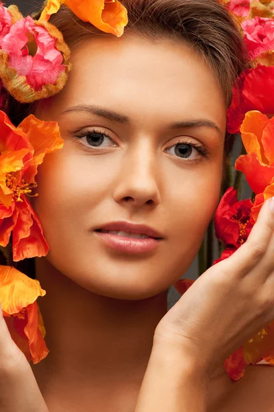 Mujer encantadora con flores rojas — Foto de Stock