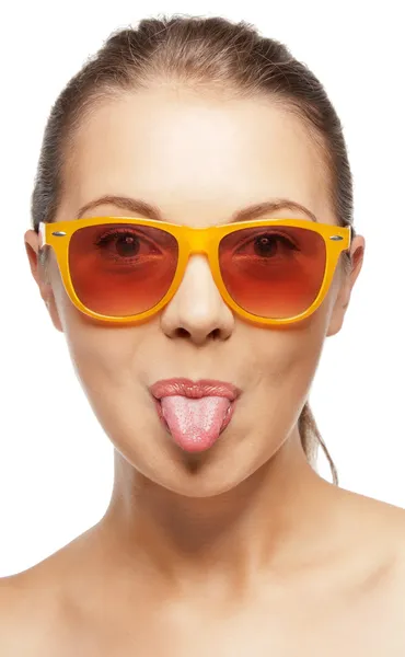 Tonårsflicka i nyanser som sticker ut tungan — Stockfoto
