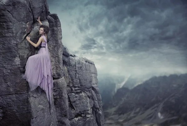 Foto conceptual de una mujer subiendo a la cima de una montaña — Foto de Stock